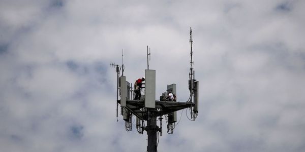 Workers install 5G telecommunications equipment on a T-Mobile US Inc tower in Seabrook, Texas, U.S. May 6, 2020. REUTERS/Adrees Latif