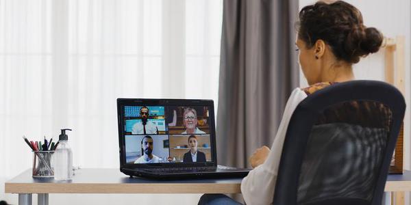 Business woman in a remote video call on laptop from home office.
